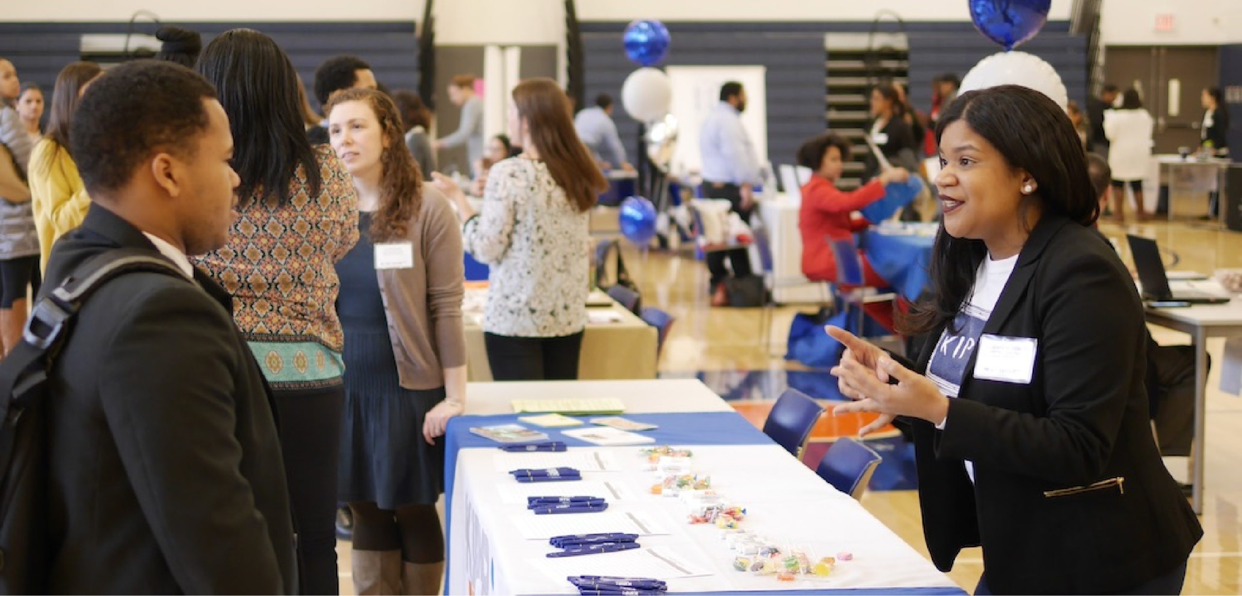 KIPP NYC Leadership Council member speaking with a student at a school event